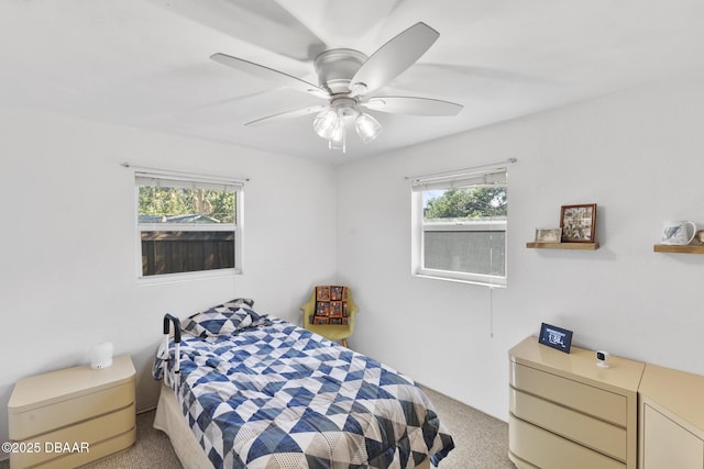 bedroom featuring light carpet, ceiling fan, and multiple windows