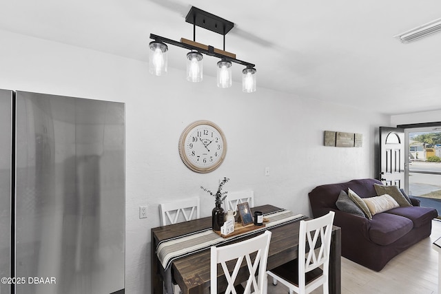 dining space featuring visible vents and light wood finished floors