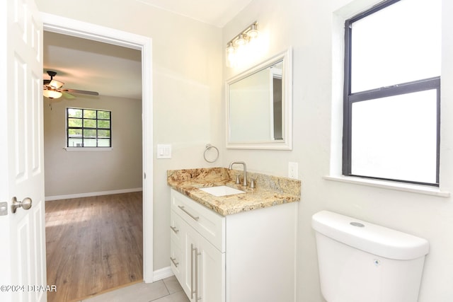 bathroom featuring hardwood / wood-style floors, ceiling fan, vanity, and toilet