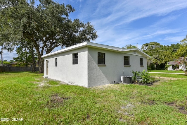 view of home's exterior with central AC unit and a lawn