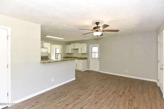 732 Orchard Ave, Ormond Beach, FL 32174 - unfurnished living room with a ceiling fan, baseboards, wood finished floors, and a sink