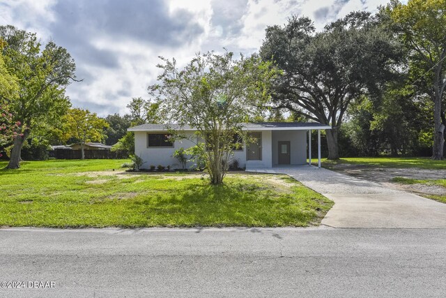 732 Orchard Ave, Ormond Beach, FL 32174 - view of front of home featuring concrete driveway, a front yard, a carport, and stucco siding
