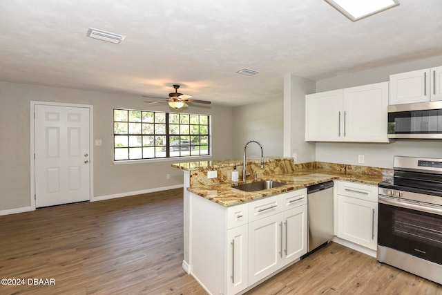 kitchen with stainless steel appliances, white cabinetry, sink, and kitchen peninsula