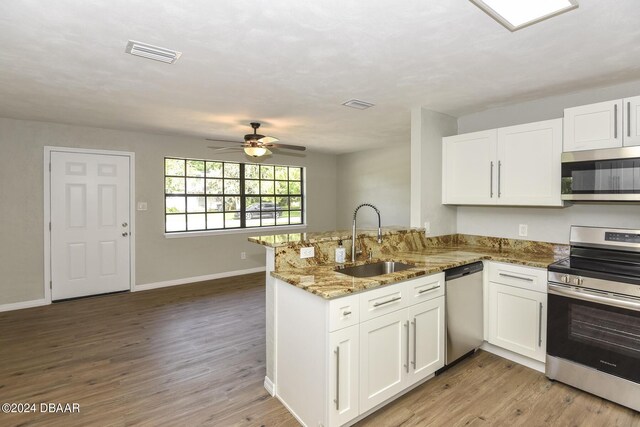 732 Orchard Ave, Ormond Beach, FL 32174 - kitchen featuring appliances with stainless steel finishes, a sink, a peninsula, and white cabinets