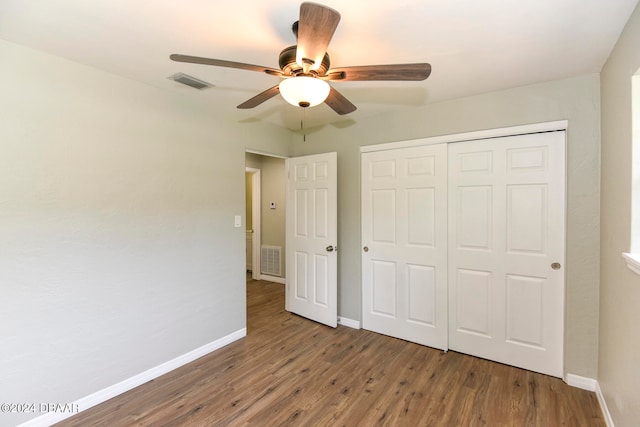 unfurnished bedroom featuring hardwood / wood-style flooring, ceiling fan, and a closet