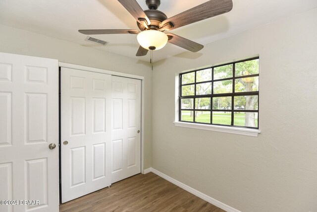732 Orchard Ave, Ormond Beach, FL 32174 - unfurnished bedroom with a closet, baseboards, wood finished floors, and ceiling fan