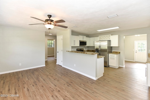 kitchen featuring white cabinets, stainless steel appliances, a healthy amount of sunlight, and kitchen peninsula