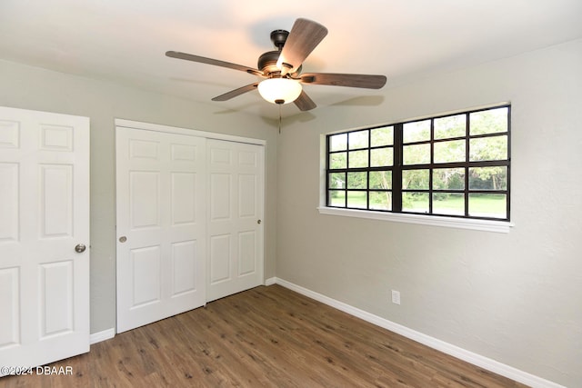 unfurnished bedroom featuring ceiling fan, a closet, and dark hardwood / wood-style flooring