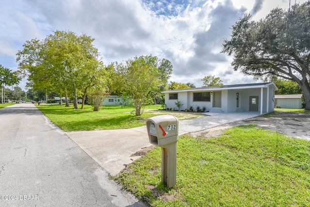 view of front facade featuring a carport and a front yard