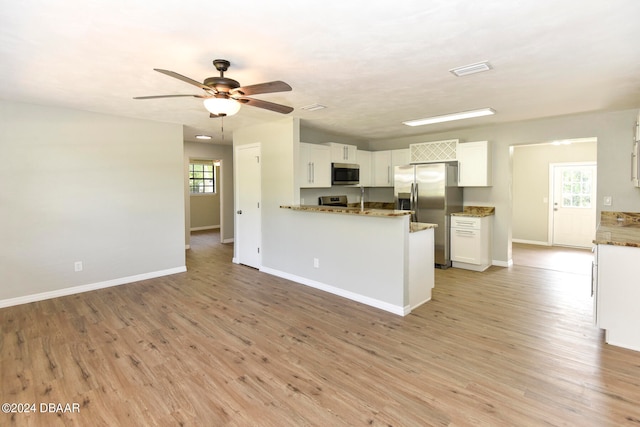 kitchen with light hardwood / wood-style flooring, white cabinetry, kitchen peninsula, and stainless steel appliances