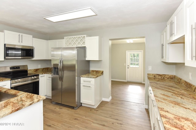 kitchen with stainless steel appliances, light hardwood / wood-style floors, white cabinets, and light stone counters