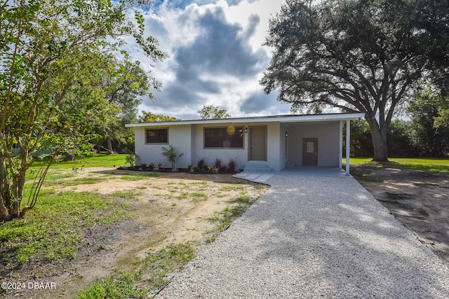 single story home featuring a carport and a front lawn