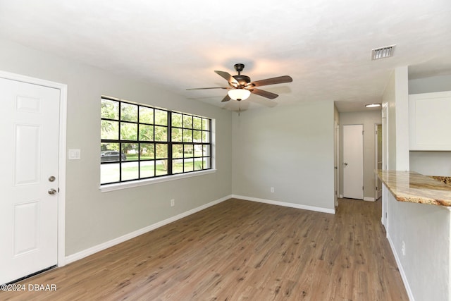 unfurnished living room with hardwood / wood-style flooring and ceiling fan