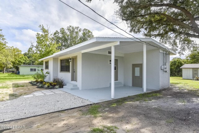 732 Orchard Ave, Ormond Beach, FL 32174 - view of front of home with an attached carport, stucco siding, and entry steps