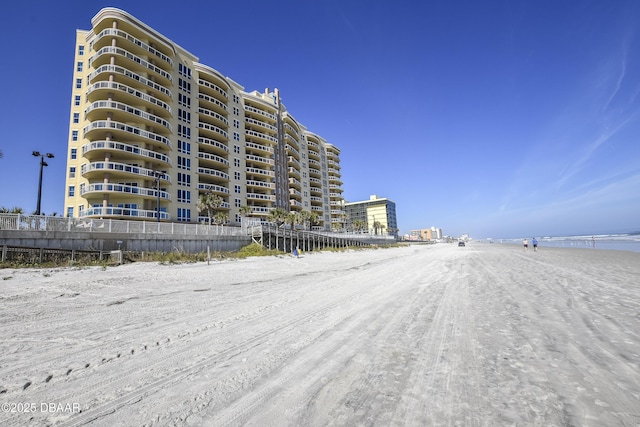 view of building exterior with a water view and a beach view