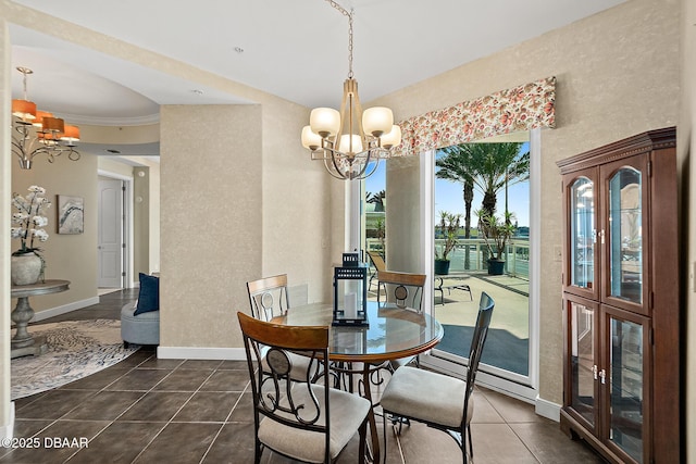 dining area with baseboards, dark tile patterned flooring, and a notable chandelier