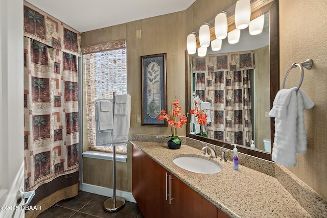 bathroom featuring curtained shower, tile patterned flooring, vanity, and baseboards