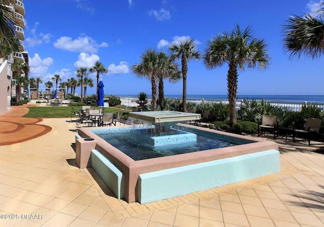 view of pool featuring a water view and a patio