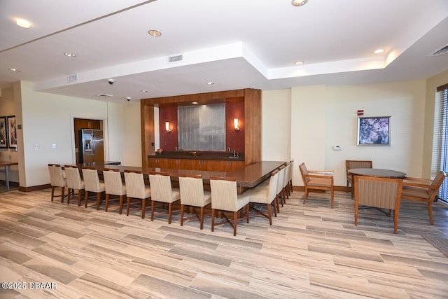 bar featuring recessed lighting, stainless steel fridge, visible vents, and baseboards