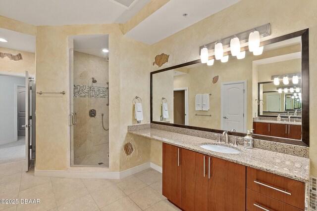 bathroom featuring baseboards, a shower stall, vanity, and tile patterned floors