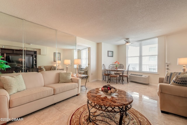 tiled living room featuring a textured ceiling, a wall mounted air conditioner, and ceiling fan