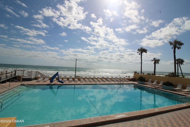 view of swimming pool featuring a water view