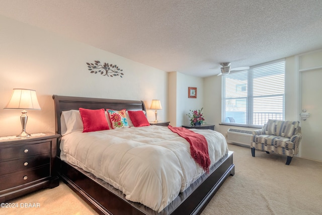 carpeted bedroom featuring a wall unit AC and a textured ceiling