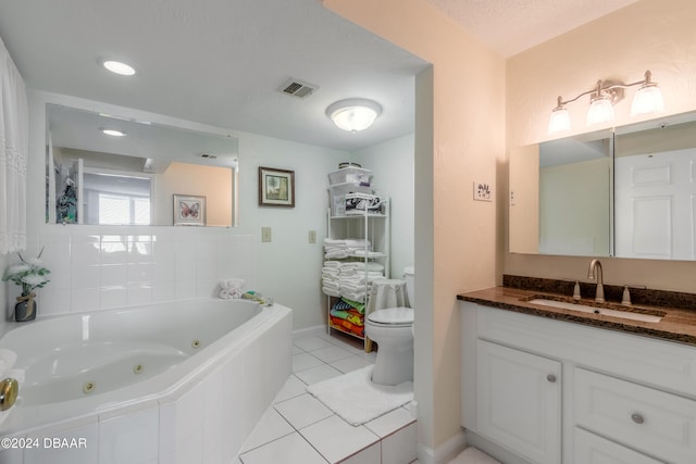 bathroom featuring toilet, vanity, tiled bath, and tile patterned floors