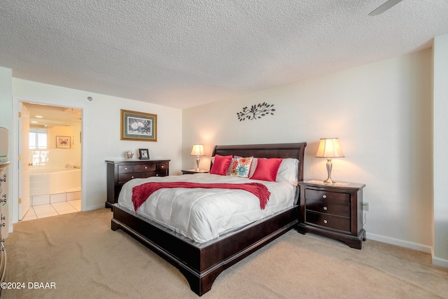 bedroom with a textured ceiling, light colored carpet, ceiling fan, and ensuite bath