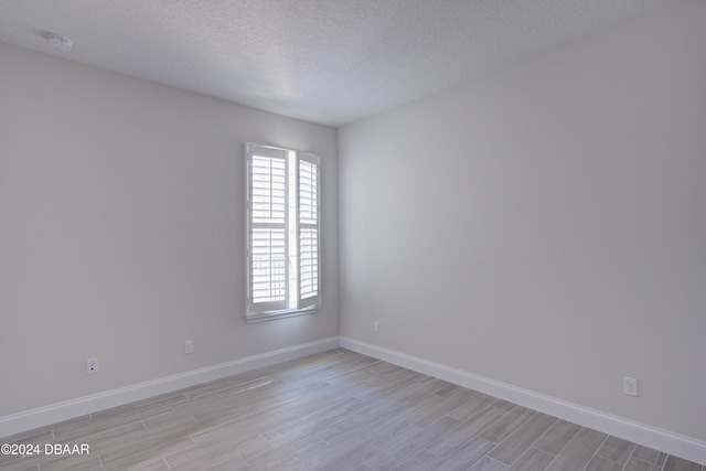 empty room featuring light hardwood / wood-style floors and a textured ceiling