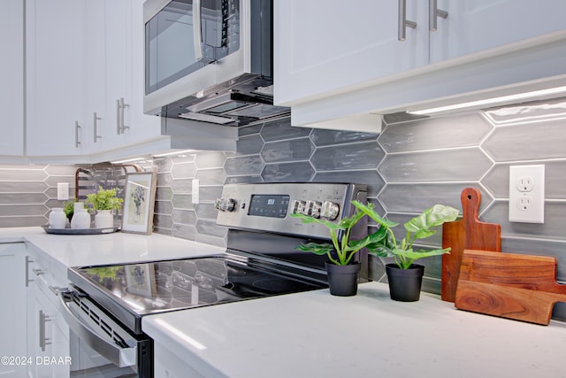 kitchen featuring backsplash, white cabinetry, and stainless steel appliances