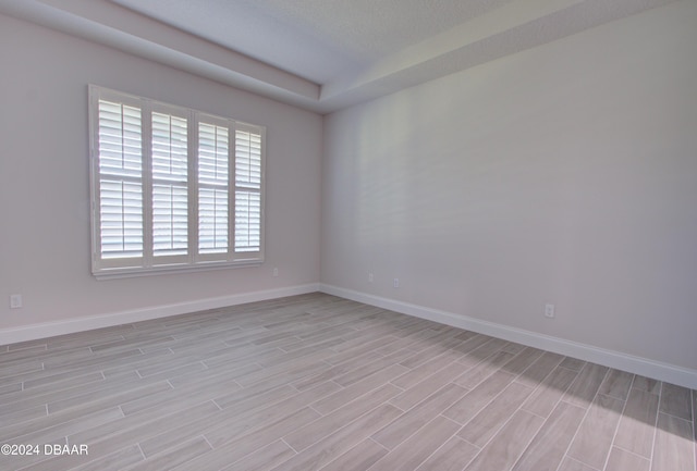 empty room featuring a textured ceiling and light hardwood / wood-style flooring