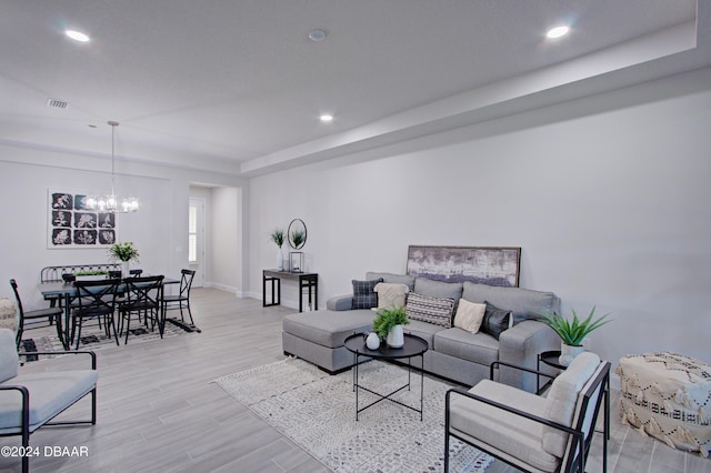 living room with light wood-type flooring and a notable chandelier