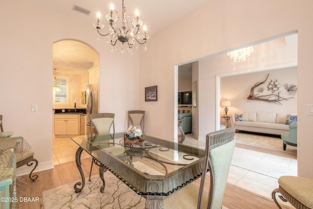 dining room featuring a notable chandelier, light hardwood / wood-style floors, and sink