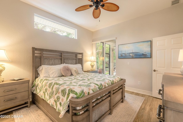 bedroom featuring ceiling fan, light hardwood / wood-style flooring, and access to outside