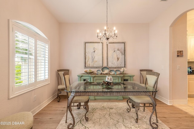 dining space featuring light hardwood / wood-style flooring and a chandelier