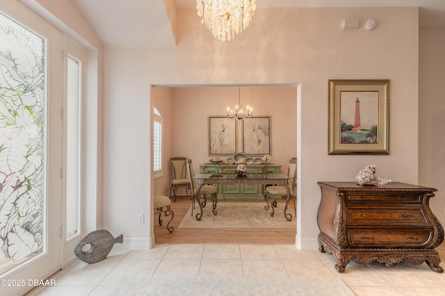 tiled foyer entrance featuring an inviting chandelier