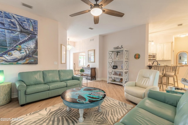 living room with light hardwood / wood-style flooring and ceiling fan