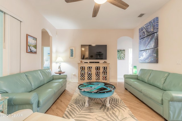 living room with light hardwood / wood-style flooring and ceiling fan