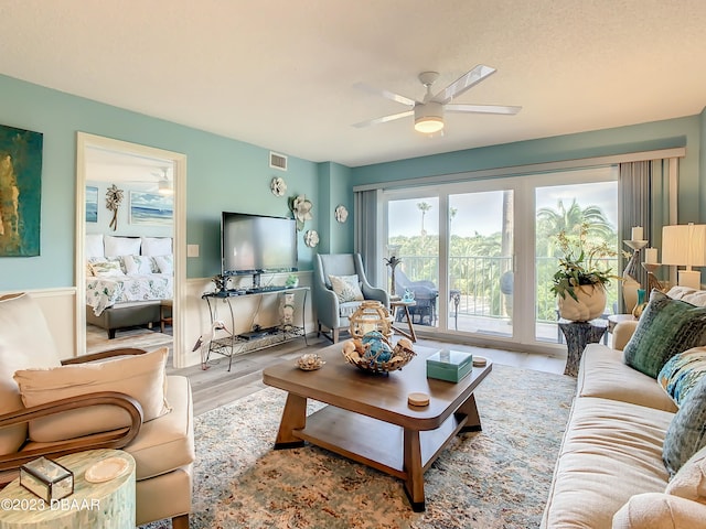 living room with light hardwood / wood-style floors and ceiling fan