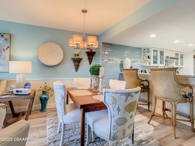 dining area featuring light hardwood / wood-style floors and a chandelier