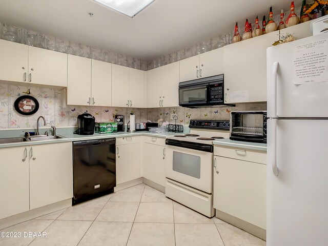 kitchen featuring light tile patterned flooring, sink, and black appliances