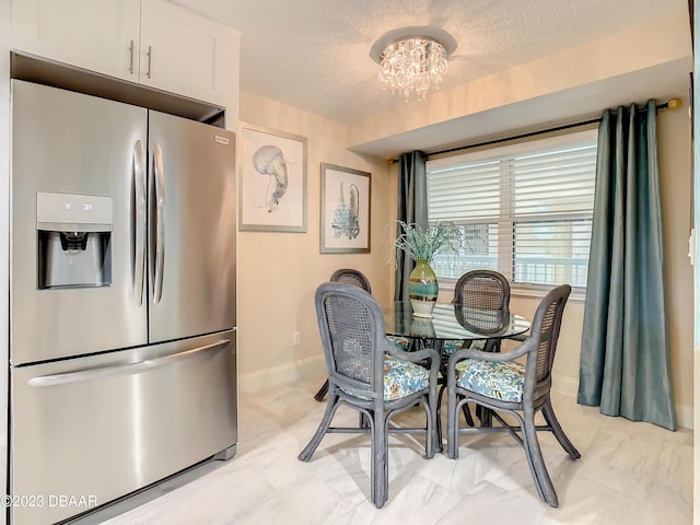 4 Oceans W Blvd Unit 307D, Daytona Beach Shores, FL 32118 - dining space featuring a chandelier, baseboards, and a textured ceiling