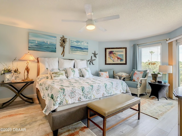 bedroom with light hardwood / wood-style floors, ceiling fan, and a textured ceiling