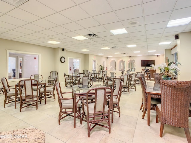 tiled dining space featuring a paneled ceiling