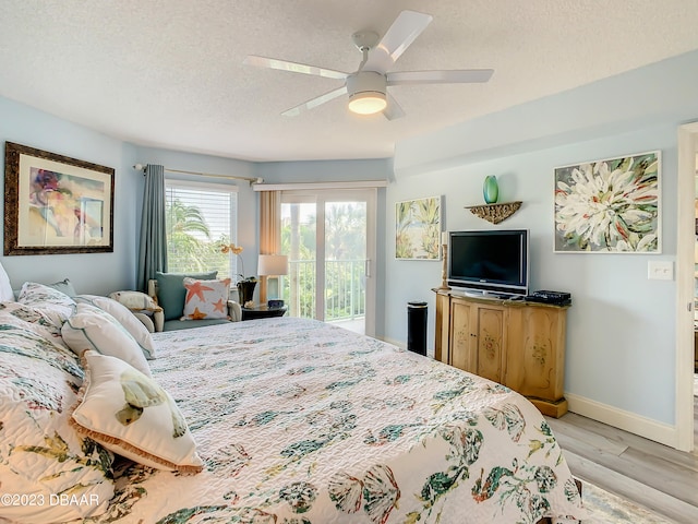 bedroom featuring access to outside, a textured ceiling, ceiling fan, and light hardwood / wood-style flooring