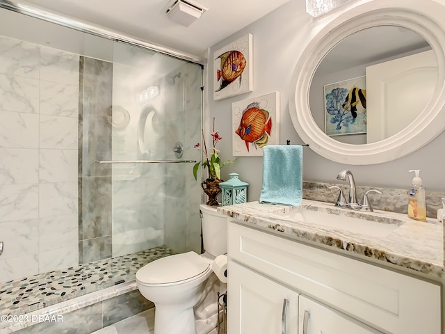 bathroom featuring toilet, vanity, tile patterned flooring, and a shower with shower door