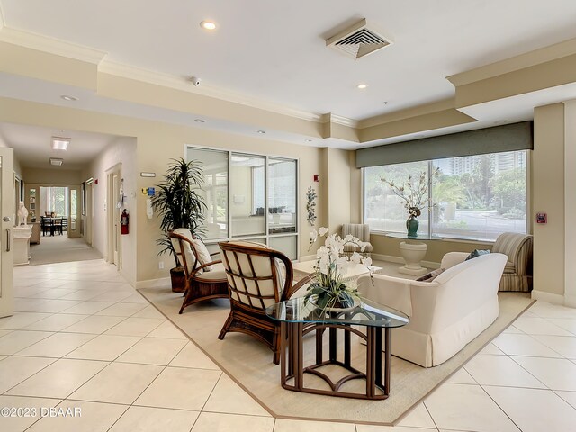 tiled living room with a healthy amount of sunlight and crown molding