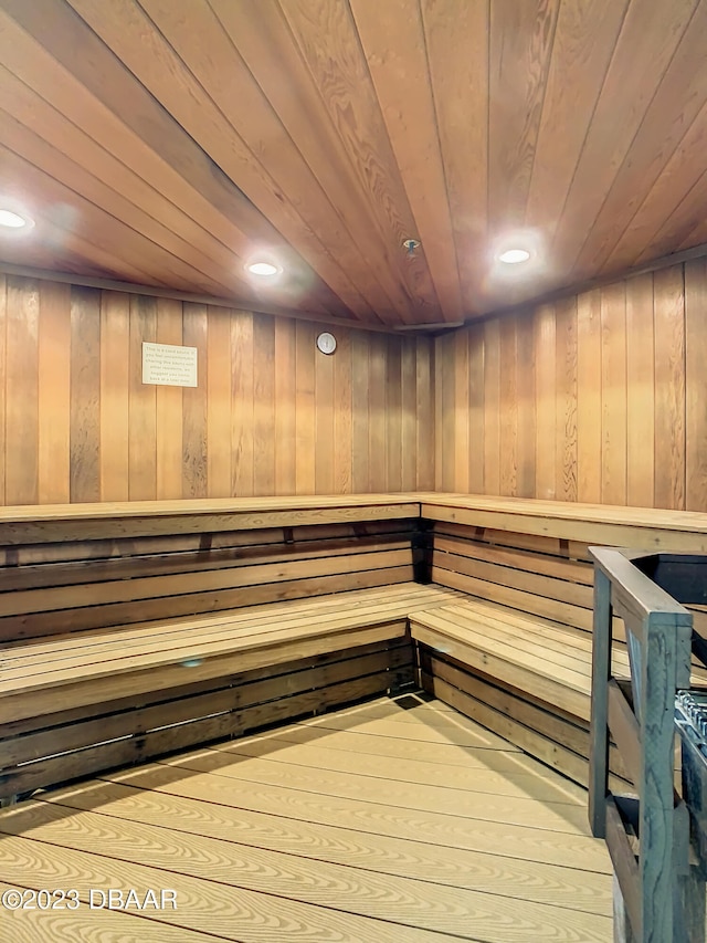 view of sauna / steam room featuring wooden walls, wood ceiling, and hardwood / wood-style flooring