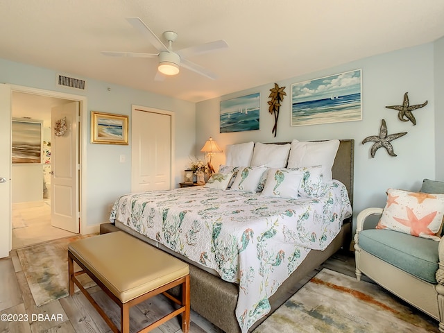 bedroom with a closet, hardwood / wood-style floors, and ceiling fan